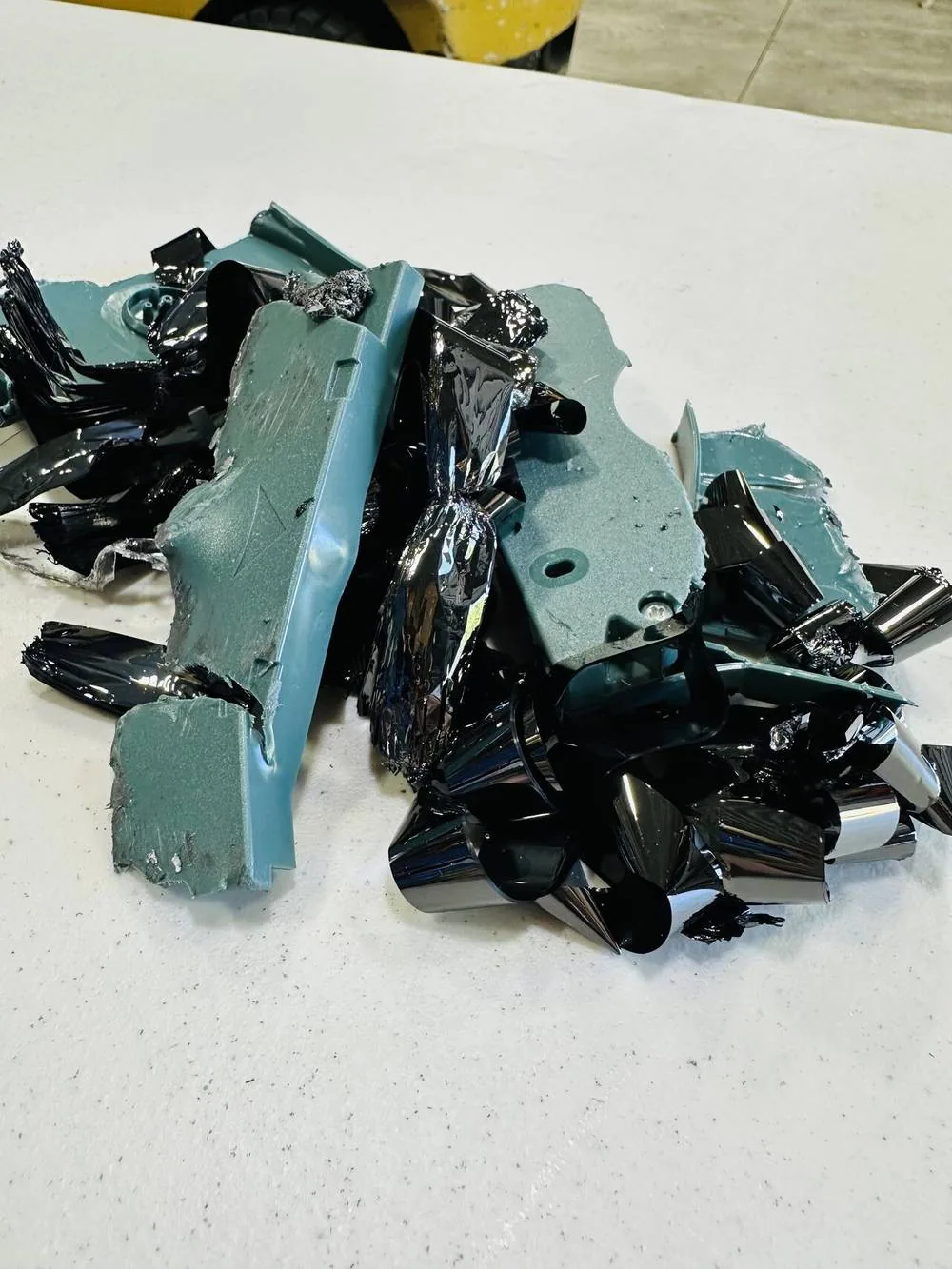 A destroyed LTO tape cartridge with the tape spooled out